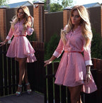 Lifestyle photo of a model walking outdoors in a long sleeve striped high-low dress